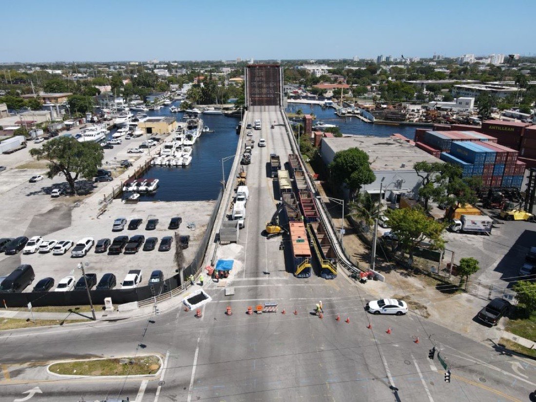 Aerial view of a drawbridge replacement project alongside a working marina and container yard