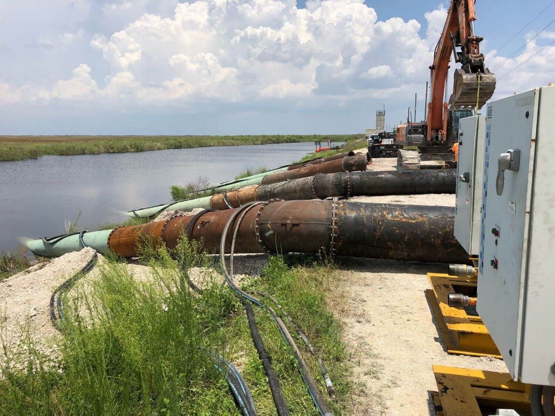 Large-diameter dewatering discharge lines and pump controls along a canal bank